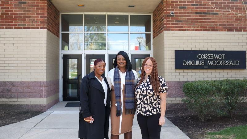 alumnae standing in front of Tomezsko Classroom Building