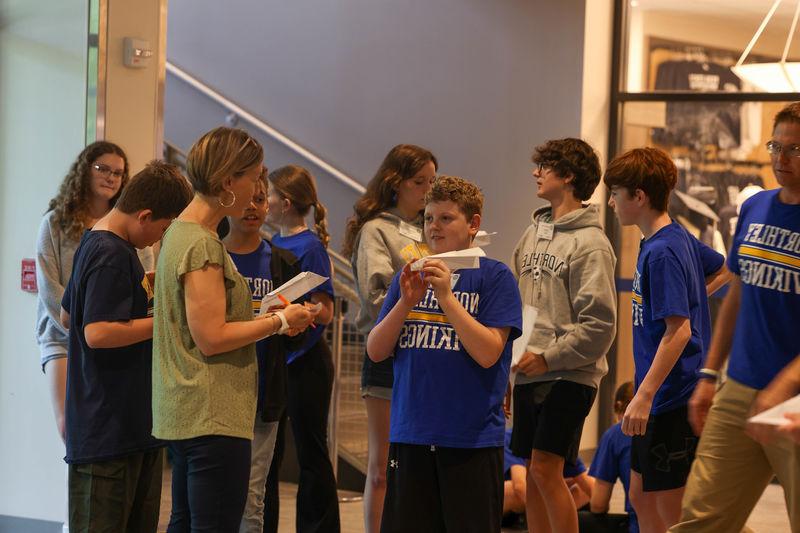 students flying paper airplanes