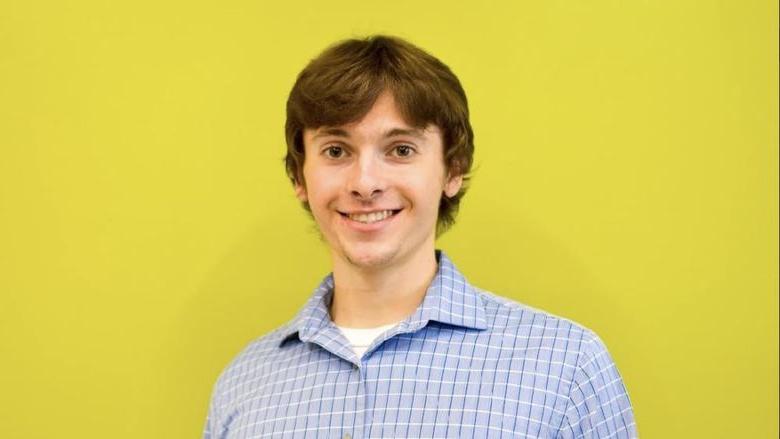 Man standing in front of bright yellow background