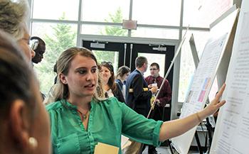 student presenting her research poster